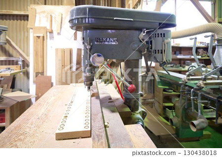 An electric drill press installed in a woodworking shop 130438018