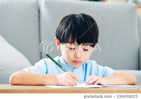 Elementary school boy studying in the living room Elementary school boy studying in the living room 130438025