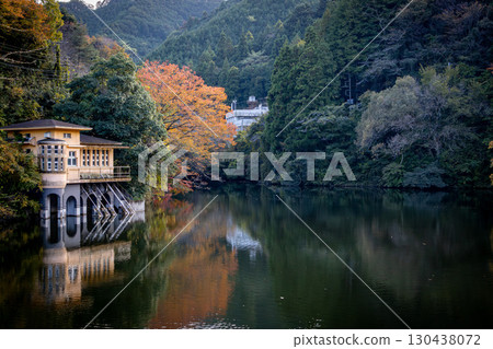 Lake Kamokita and the Water Management Building during the autumn foliage season 130438072