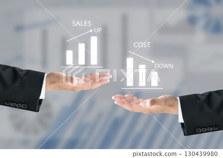 Business team holding up bar graphs showing sales increase and cost reduction 130439980