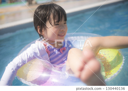 Girl floating in the pool on a swim ring 130440136