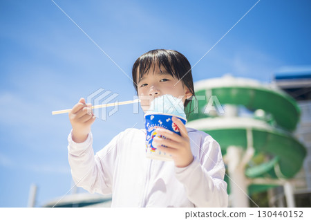 女孩在泳池邊吃刨冰 130440152