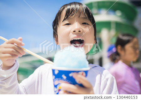 女孩在泳池邊吃刨冰 130440153