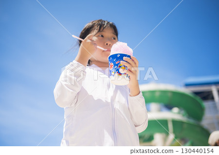 女孩在泳池邊吃刨冰 130440154