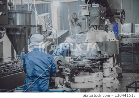 Quiet factory, few plant worker cleaning production line convey belt prepare to close food factory 130441513