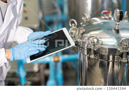 closeup staff hand work in science medical lab factory check record pressure tank with tablet closeup staff hand work in science medical lab factory check record pressure tank with tablet 130441594