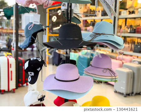 Bright summer hats on store rack. Fashion, tourism, and lifestyle accessories for sunny days. Bright summer hats on store rack. Fashion, tourism, and lifestyle accessories for sunny days. 130441621