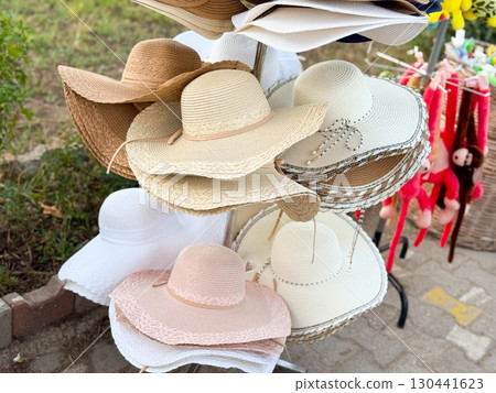Bright summer hats on store rack. Fashion, tourism, and lifestyle accessories for sunny days. Bright summer hats on store rack. Fashion, tourism, and lifestyle accessories for sunny days. 130441623