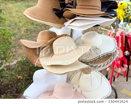 Bright summer hats on store rack. Fashion, tourism, and lifestyle accessories for sunny days. Bright summer hats on store rack. Fashion, tourism, and lifestyle accessories for sunny days. 130441624