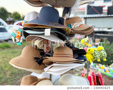 Bright summer hats on store rack. Fashion, tourism, and lifestyle accessories for sunny days. Bright summer hats on store rack. Fashion, tourism, and lifestyle accessories for sunny days. 130441625