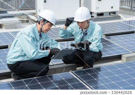 Worker maintaining solar panels 130442028