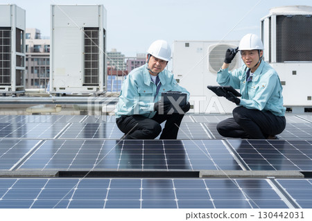 Worker maintaining solar panels 130442031