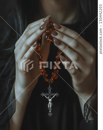A person holds a rosary with a crucifix, engaging in prayer, reflecting deep spirituality and faith 130442203