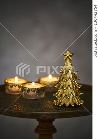 Christmas tree and candles on an antique side table 130442754