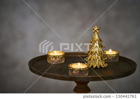 Christmas tree and candles on an antique side table 130442761