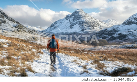 A hiker journeys through a stunning winter landscape. Snow blankets the ground. Majestic mountains tower in the background. The beauty of nature awakens inspiration. Generative AI 130443090