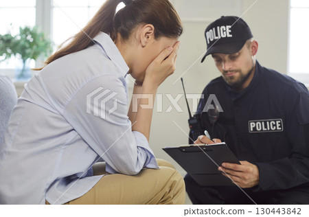 Crying woman gives statement to police officer at home Crying woman gives statement to police officer at home 130443842