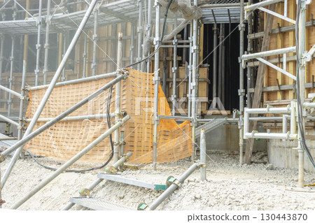Scaffolding around the perimeter of a reinforced concrete building under construction 130443870