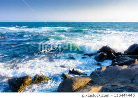 rocks at the black sea shore in summer. waves crashing coast of bulgaria on a sunny morning. cloudless blue sky. travel background at the seaside 130444440