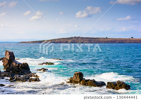 rocks at the black sea shore in summer. waves crashing coast of bulgaria on a sunny morning. cloudless blue sky. travel background at the seaside 130444441