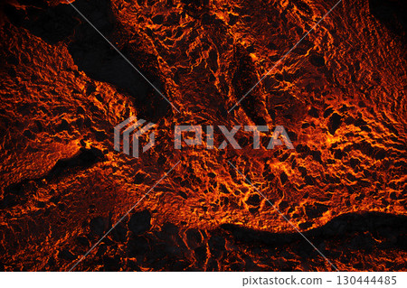 Close-up shot of glowing molten lava with bright orange cracks and a textured surface. Close-up shot of glowing molten lava with bright orange cracks and a textured surface. 130444485