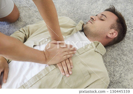 Emergency resuscitation training with chest compressions on an unconscious patient 130445339