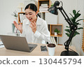 surprised woman working with laptop computer at home office 130445794