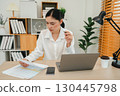 stressed woman working with document and laptop at home office 130445798