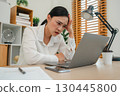 stressed woman headache while working with laptop computer at home office 130445800
