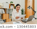 haapy woman reading document or paperwork. working at home office 130445803