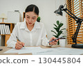 business woman using smartphone and writing document. working at home office 130445804