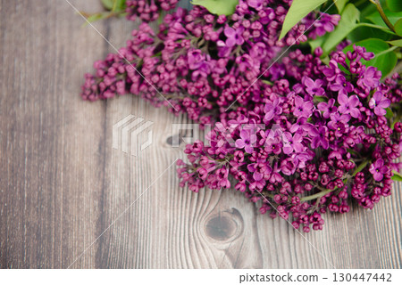 Branch of beautiful lilac flowers on wooden surface Branch of beautiful lilac flowers on wooden surface 130447442