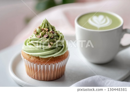Delicious green tea cupcake with frosting topping and cup of matcha latte 130448381
