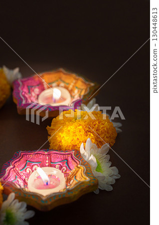 Colorful Diwali candles surrounded by marigold flowers 130448613