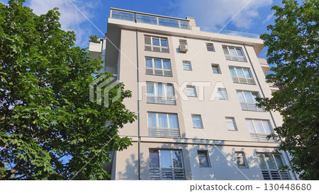 Modern residential building surrounded by greenery on a sunny day in an urban area Modern residential building surrounded by greenery on a sunny day in an urban area 130448680