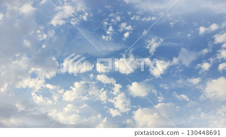 Cloud formations in a bright blue sky during the afternoon hours 130448691