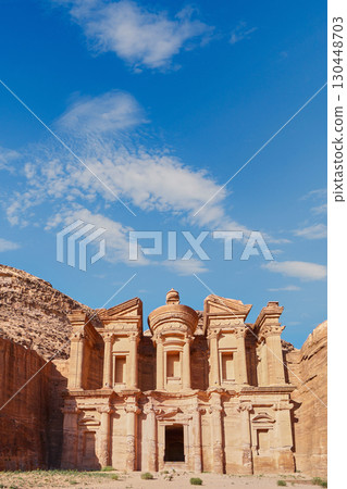Petra, Jordan. Ancient rock temple stands majestically against a clear blue sky in desert landscape Petra, Jordan. Ancient rock temple stands majestically against a clear blue sky in desert landscape 130448703