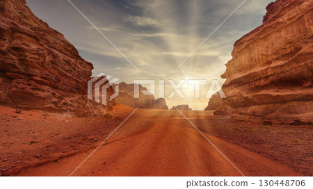 Sunset casts golden light over red rock formations in desert landscape. Wadi Rum, Jordan. Sunset casts golden light over red rock formations in desert landscape. Wadi Rum, Jordan. 130448706