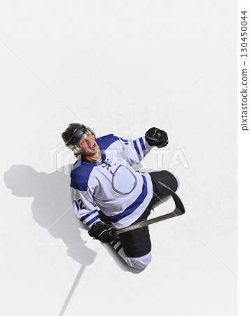 Top angle hockey forward in blue jersey shouting with joy after scoring Top angle hockey forward in blue jersey shouting with joy after scoring 130450044