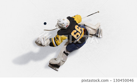 Overhead view hockey goalkeeper in yellow jersey leaping to block puck 130450046