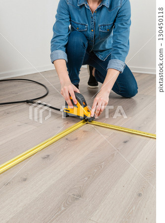 DIY home project measuring with laser tool on wooden floor, creativity DIY home project measuring with laser tool on wooden floor, creativity 130450118