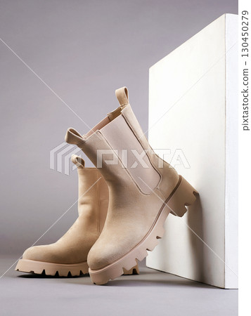 Trendy suede boots with white cube. fashion female shoes still life 130450279