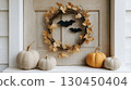 Charming autumn door wreath with bats and pumpkins - a cozy halloween decor scene 130450404