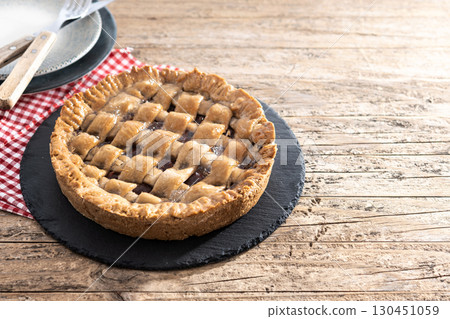 : Slice of traditional Pastafrola pie with guava filling, also known as Cuban pae on rustic wooden table. 130451059