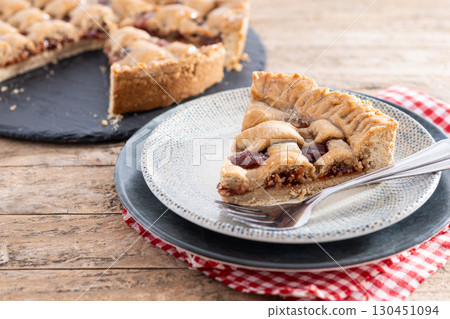 : Slice of traditional Pastafrola pie with guava filling, also known as Cuban pae on rustic wooden table. 130451094