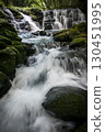A waterfall leading to the Kikuchi Gorge with a clear stream flowing through nature 130451995