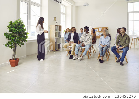 Woman business coach meeting with a team of diverse employees in an office workplace 130452279