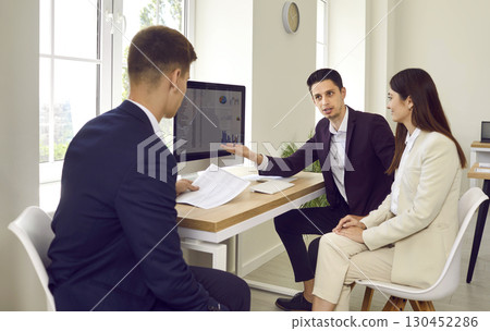 Business people discussing financial diagram, charts on pc computer screen in office. 130452286