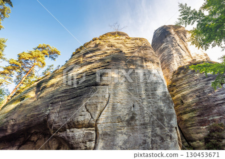 Adrspach-Teplice Rocks, sandstone formations in Hradec Kralove Region in Czech Republic, Europe. Towering rock formations dominate landscape, sculpted by time and nature's artistry under a blue sky. 130453671