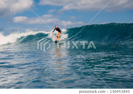 Woman surfer ride on surfboard on breaking wave Woman surfer ride on surfboard on breaking wave 130453845
